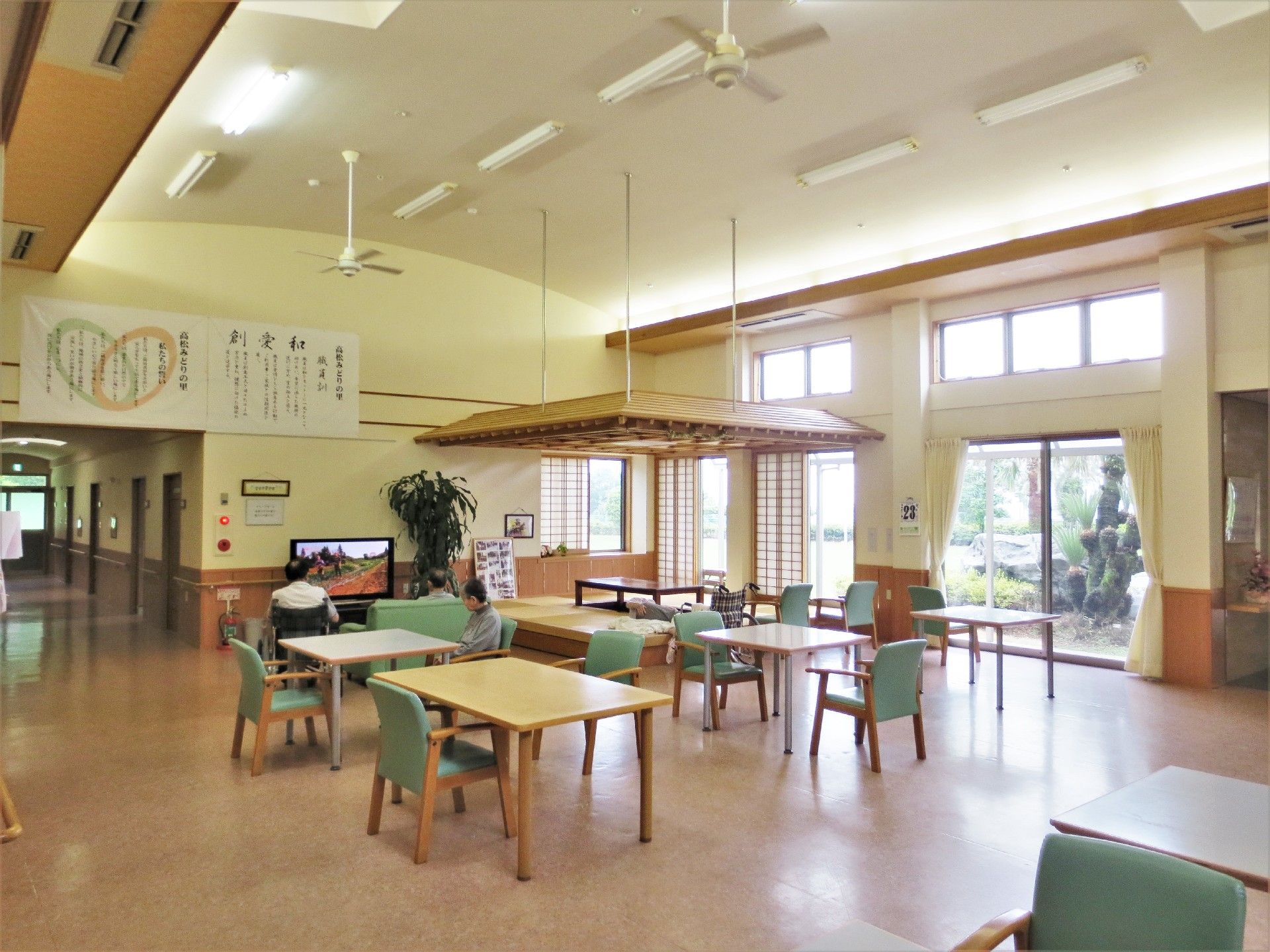 天井の高いリビングダイニングの一角には畳敷きの和室もあり、大きなテレビがあるスペースもある。