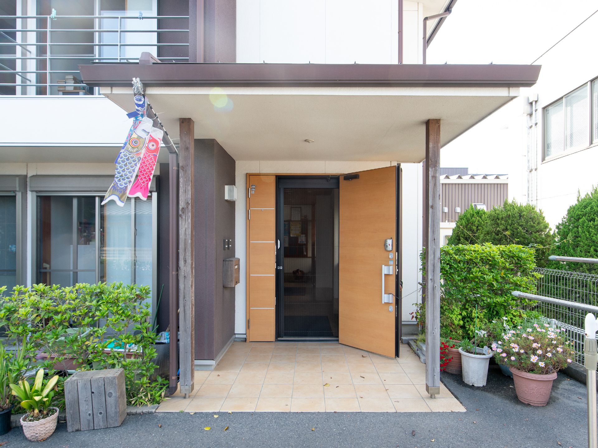 ドアの上にせり出した屋根にこいのぼりが飾られている玄関前