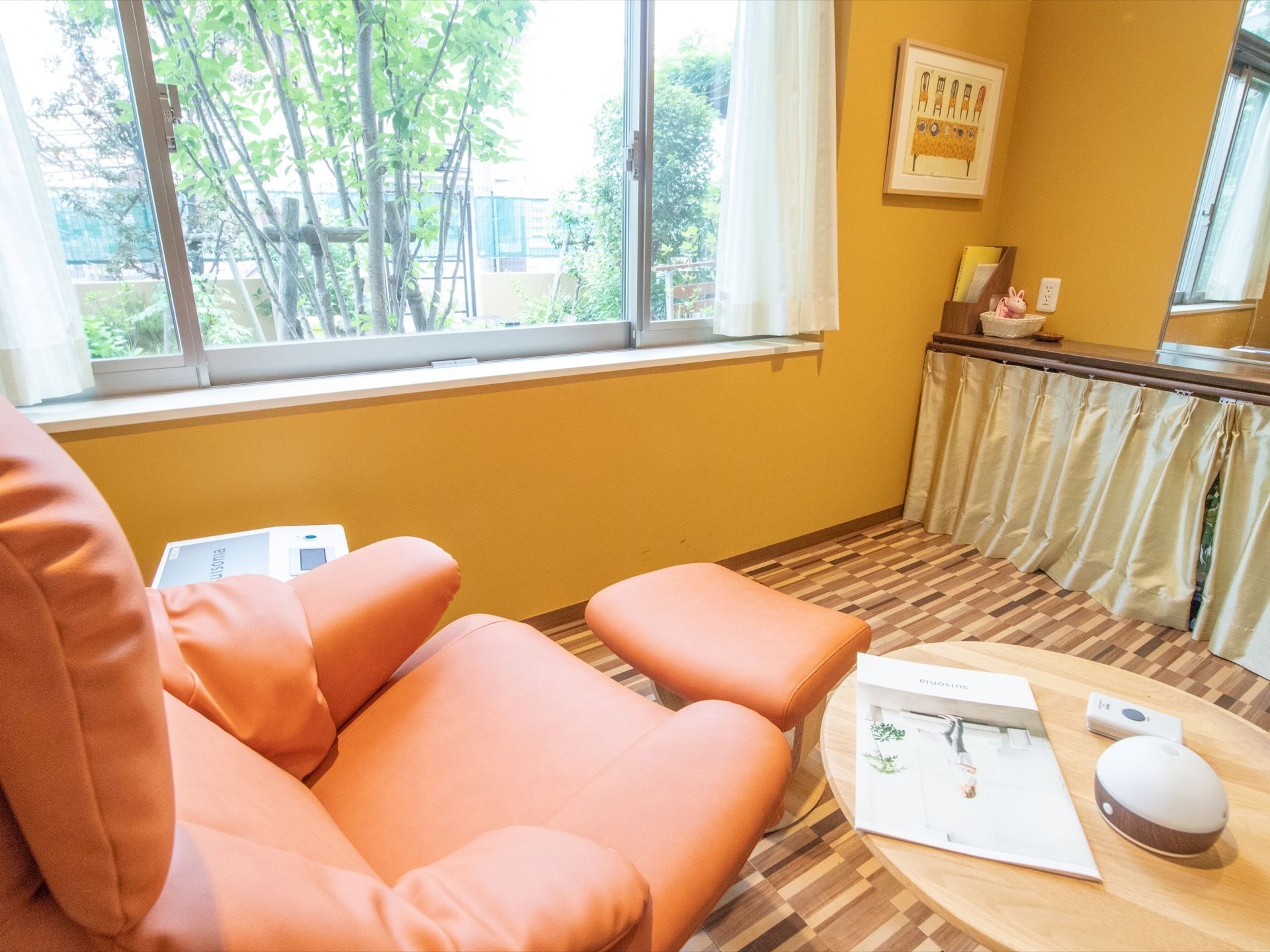 窓際の部屋にはリクライニング付きのソファに、足置きが用意されている。袖机にアロマ加湿器が置かれている。