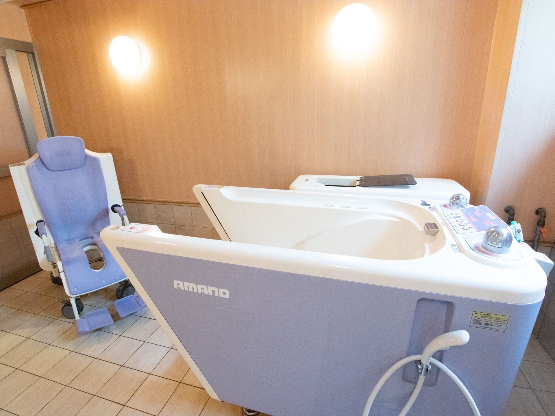 個浴用浴室には座位入浴用の特殊浴槽が用意されている。照明は２か所に取りつけられ、床はタイルが貼られている。