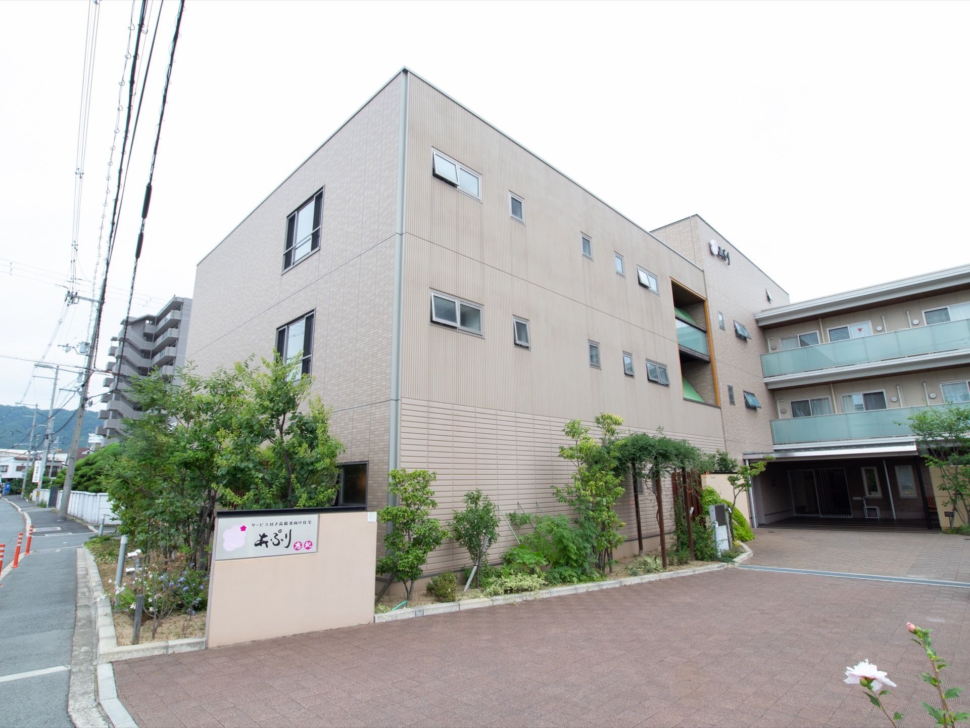 ３階建ての施設で、建物周囲はたくさんの植栽に囲まれている。施設入口に施設名を表示した看板を掲示している。