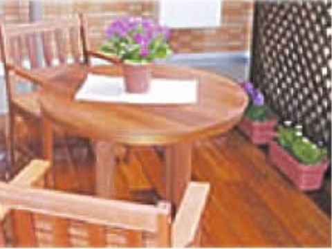 木製のテーブルセットの前にプランターに植えられた花があるデッキ