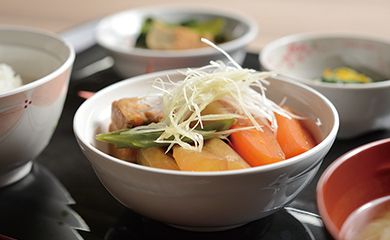 ねぎの乗った野菜の煮物と小鉢がセットになった和食