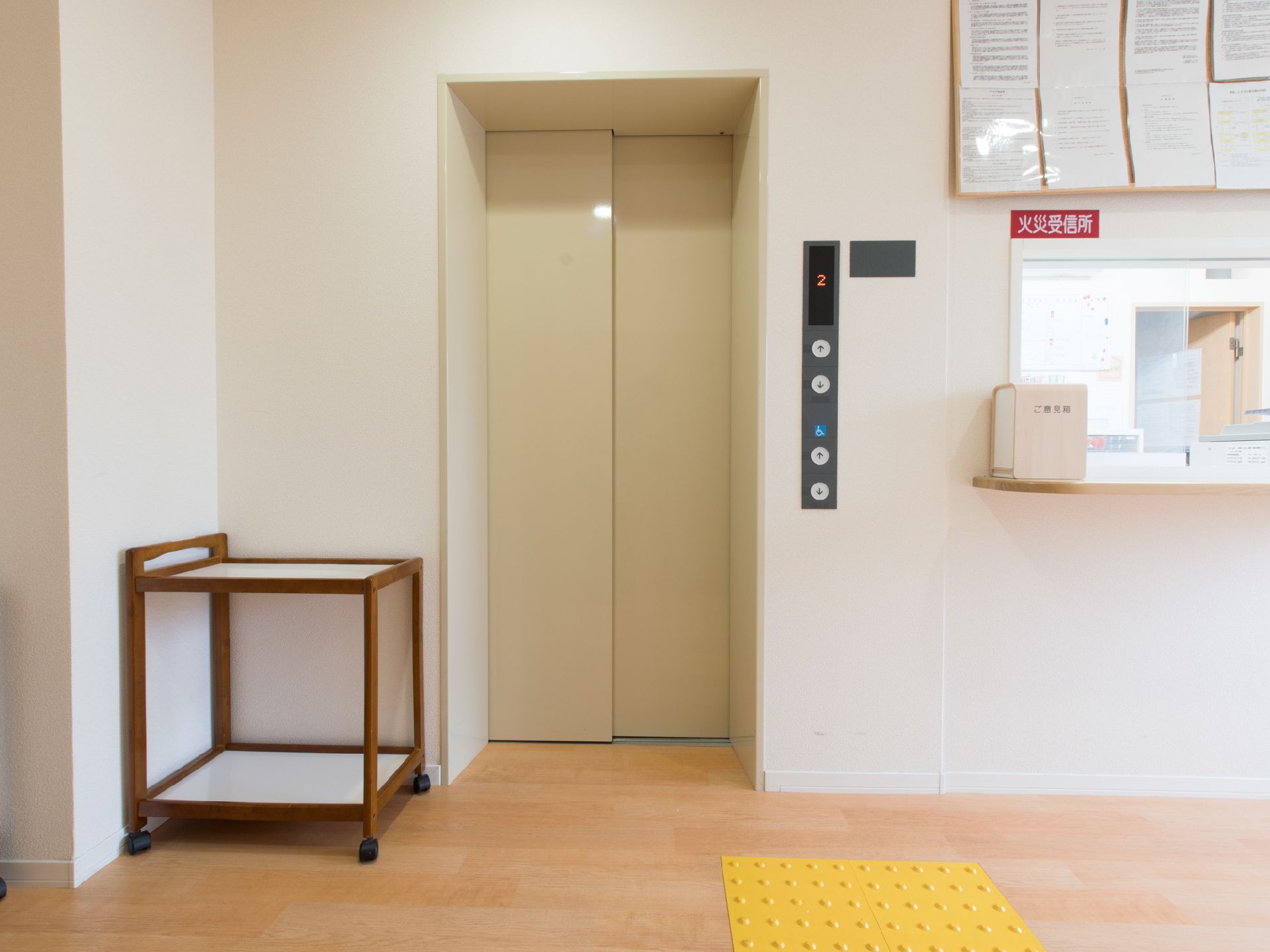 エレベーターの隣に受付があり、火災受信所になっている。カウンターにはご意見箱が置かれている。足元には点字ブロックがある。