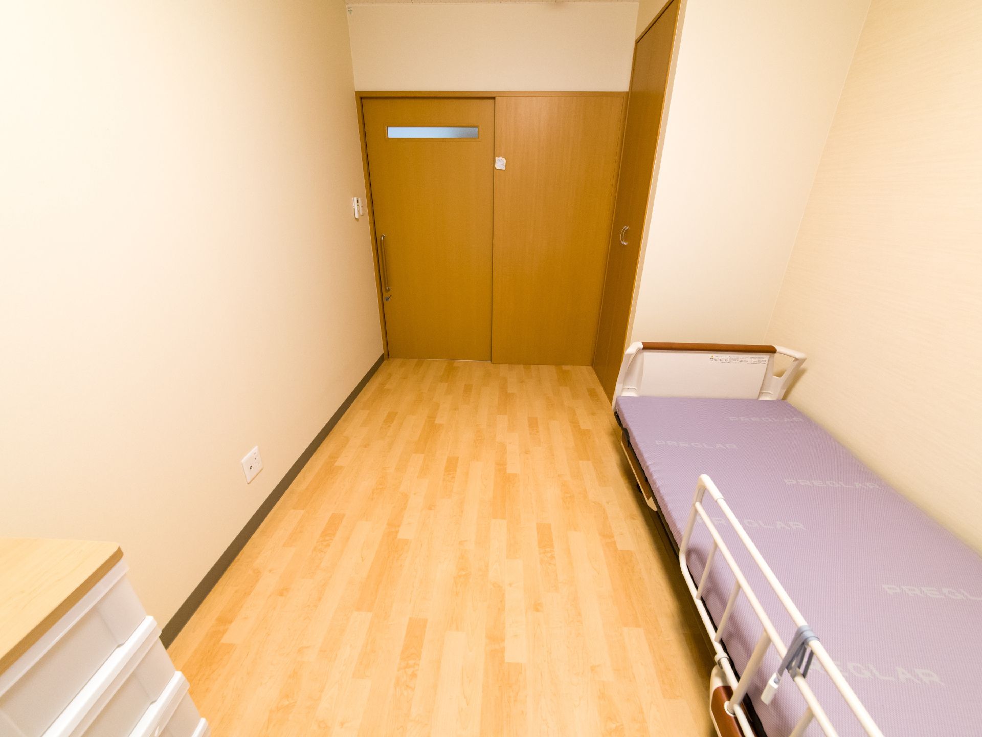居室のベッド側から入り口を見たところ。室内には他にはクローゼット以外の設備はなく、風呂やトイレは共用である事が分かる。
