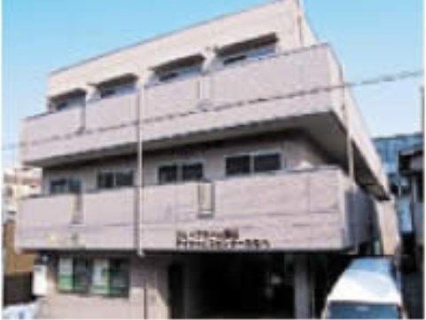 ２階のベランダ部分に茶色い文字で施設名が書かれている外観