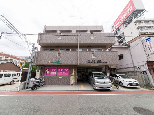 3階にはベランダがある。車は玄関前と横に数台停めれる。周りはビルや家に囲まれている。"