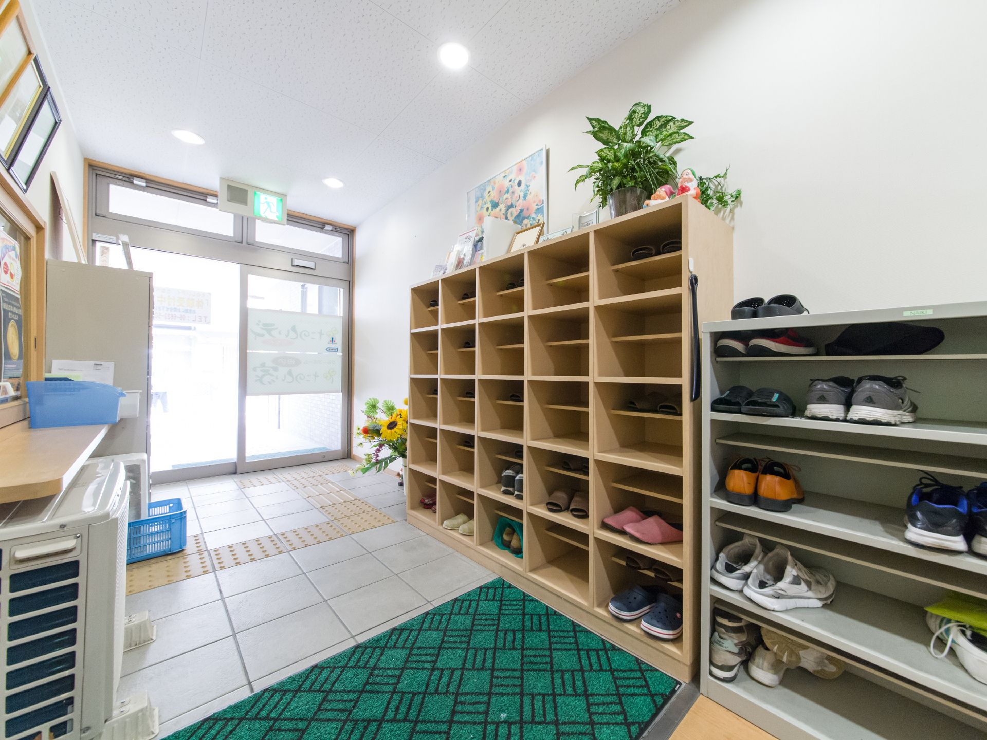 木製のものと、鉄製のもの２種類の下駄箱が置かれたエントランス