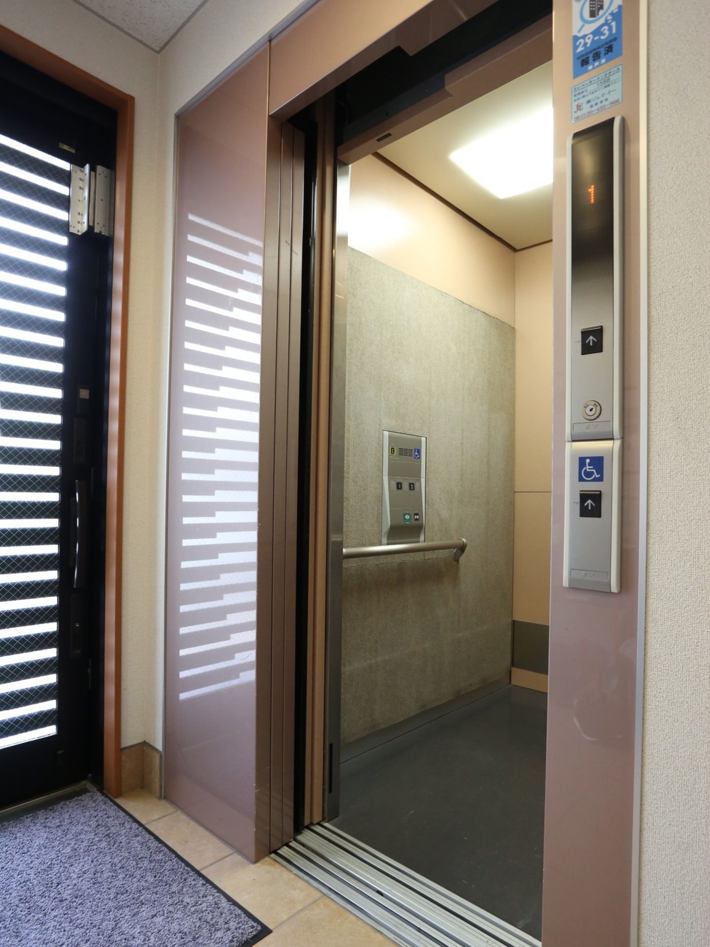 施設内に完備されているエレベーターである。扉が開かれ、庫内に設置されている手すりが見える。車椅子をご利用の方もスムーズに利用できる。