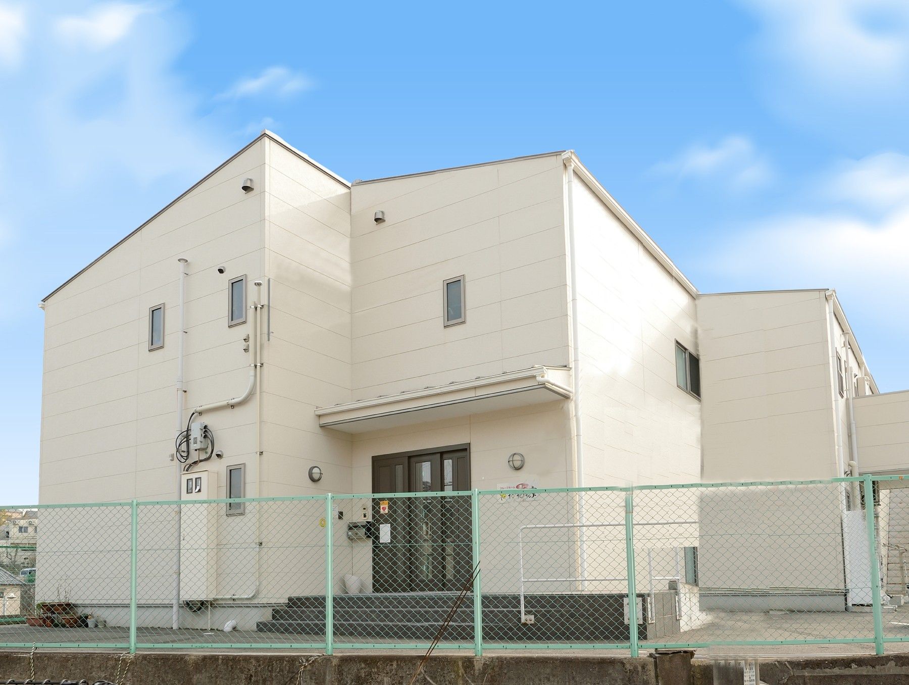 白い壁に大きく施設名とロゴマークが取り付けられている外観