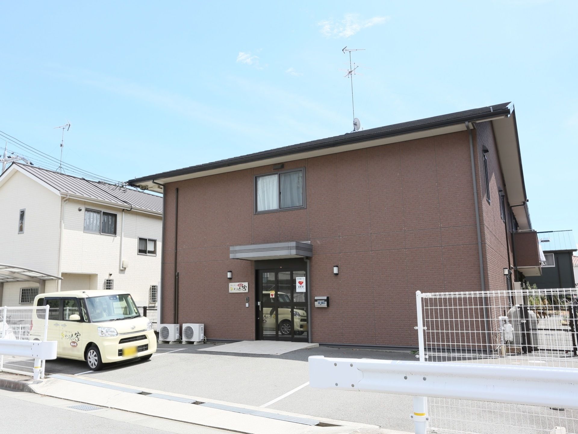 ２階建ての鉄筋コンクリートの建物であり、施設前は駐車スペースが設けられている。歩道とは白いフェンスで区切られている。