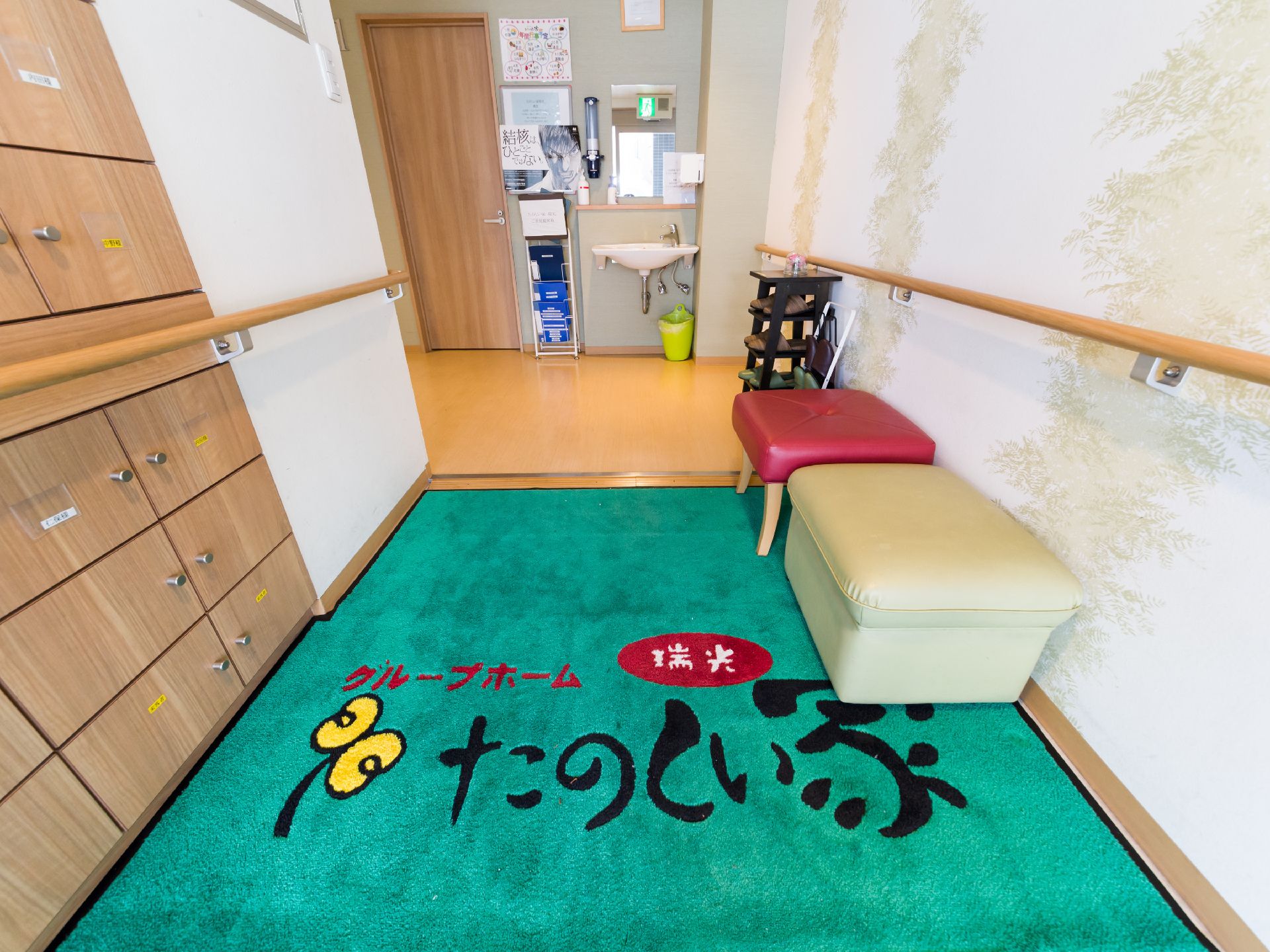 玄関土間と上がりかまちは段差がないため、車椅子でも移動がしやすくなっている。壁には手すりがついている。洗面台が置いてある。
