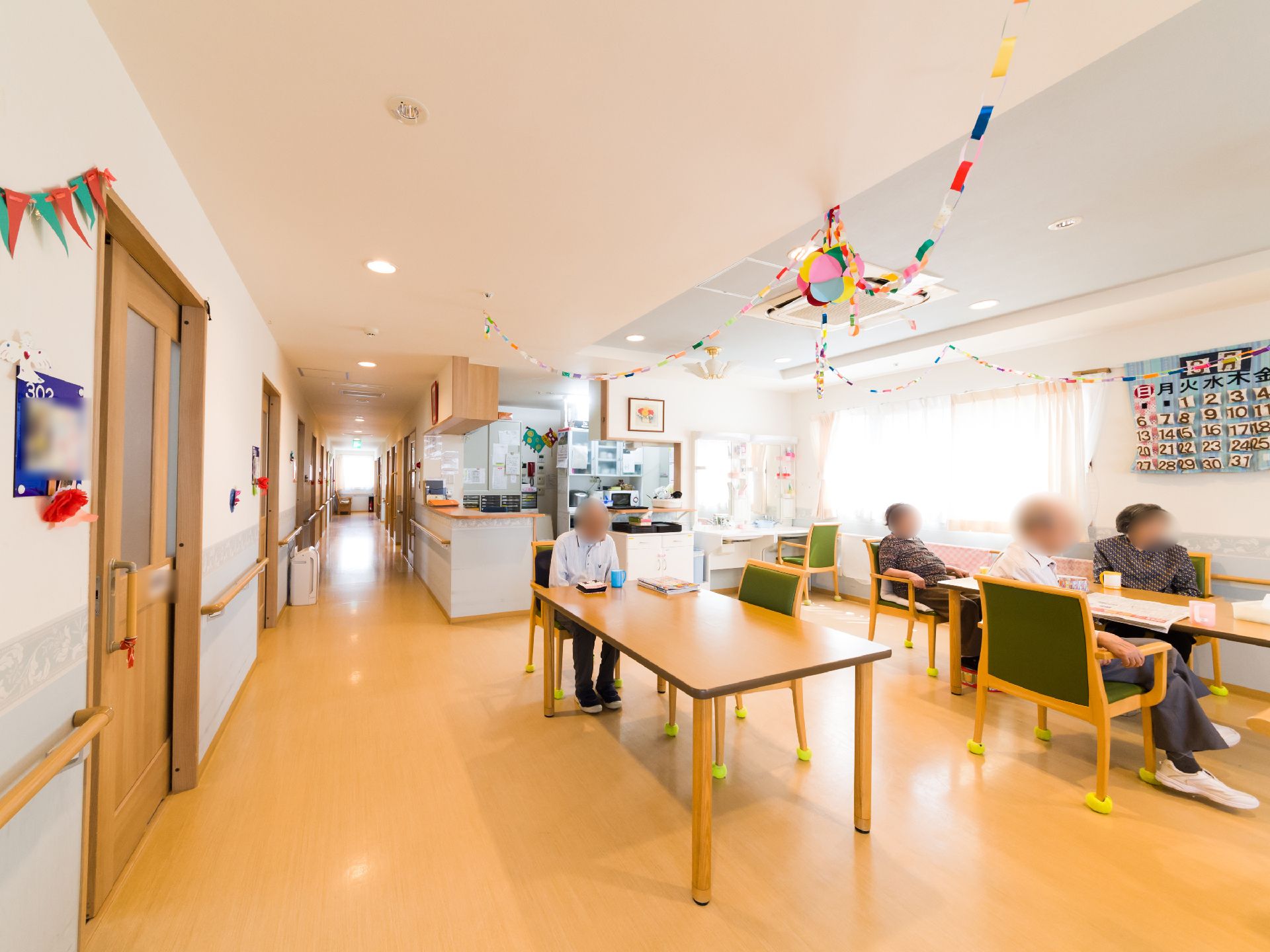 廊下の左右に部屋がある。部屋の入り口すぐの壁から手すりが設けてあるので、伝いながら食堂などへ行くことができる。