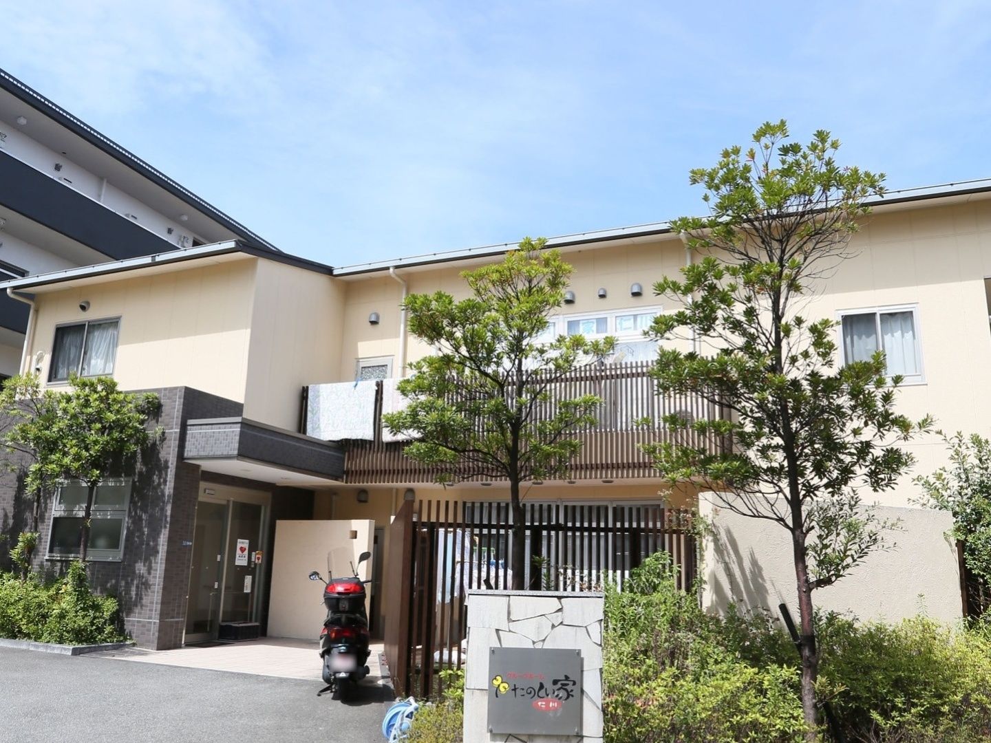 建物の周りの植え込みを活用して、緑の多いホームである。高い樹木は２階まで届き、目隠しとしても機能している。