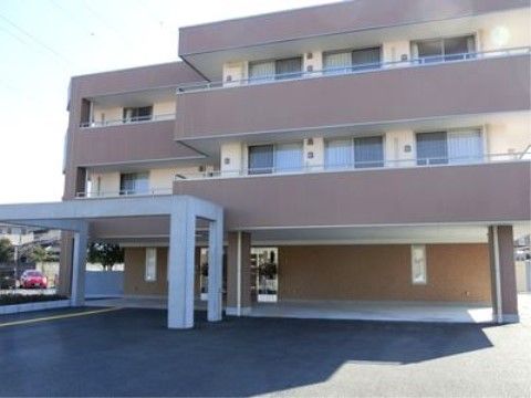 各居室にベランダが付いており、ベージュと茶色の2色使いの施設外観