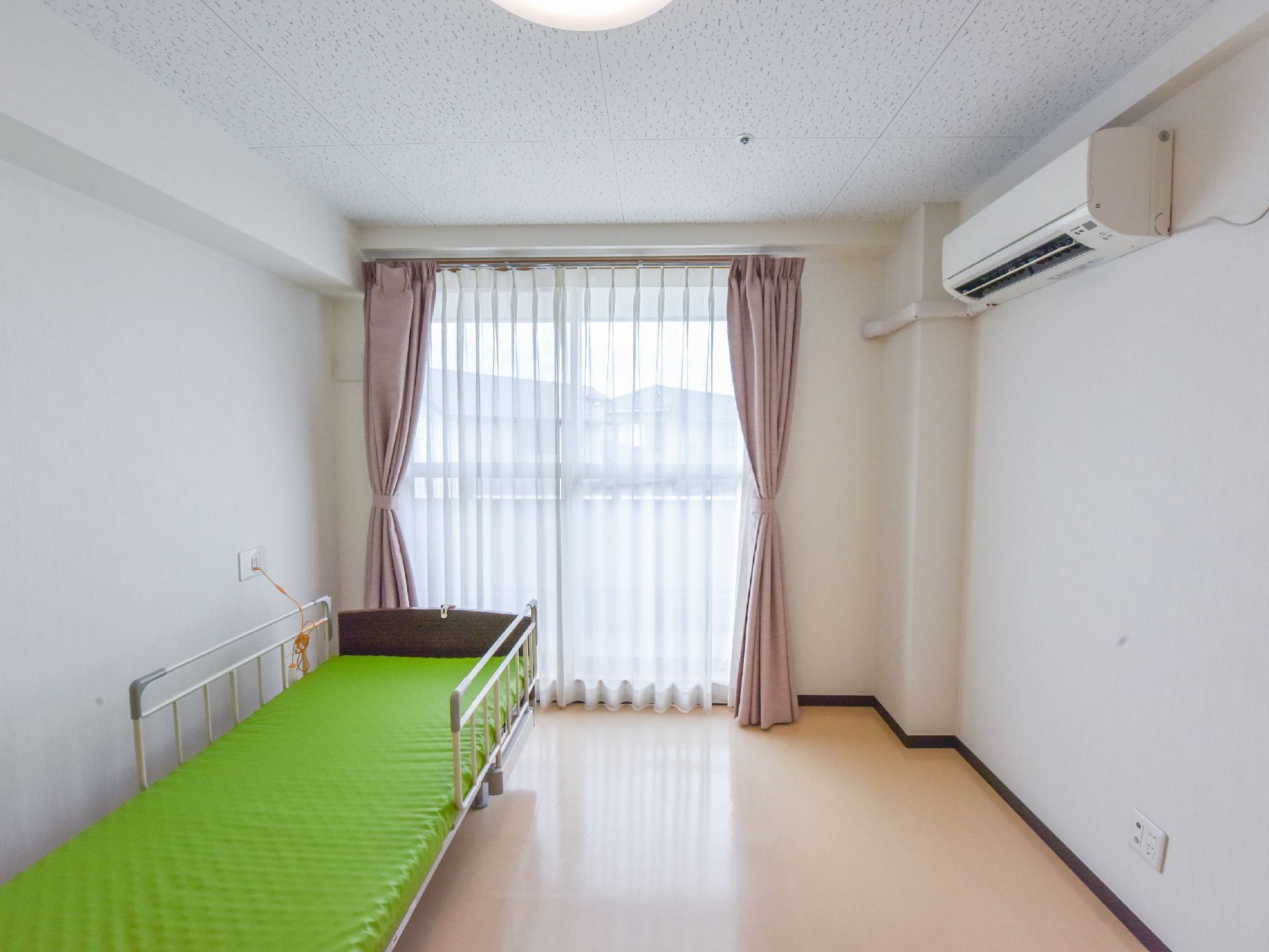 居室には掃き出し窓があり、カーテンが掛けられている。外部はバルコニーになっており、外を眺める事が出来る。