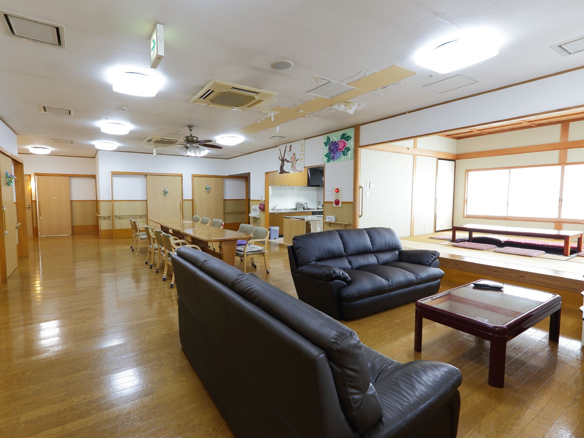 広い部屋にダイニングテーブルと椅子、ソファーがある。畳敷の部屋が一段高い所にある。キッチンが横にあり扉が開いている。