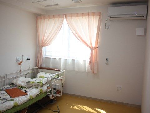 「はっぴーらいふ茨木」の居室。介護ベッド横に、体調や息苦しい場合に、緊急コールを設置している。