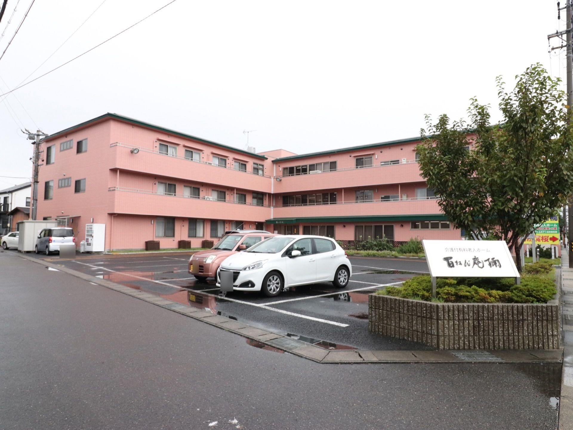 施設の建物は3階建てで、2階以上にはベランダを設置している。前面にはアスファルト舗装の駐車場を設けている。