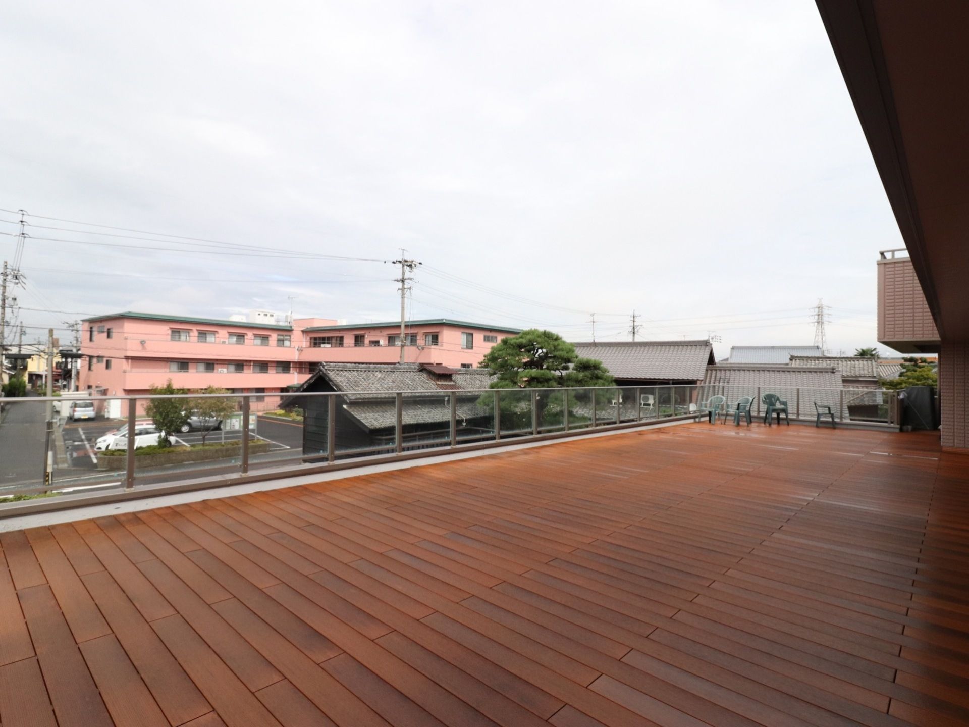 建物の外に設けたテラスにはフラットな板張りのフロアが広がっている。コーナー部分にはグリーンのガーデンセットを置いている。
