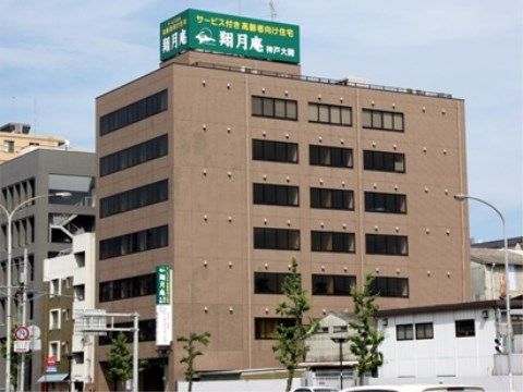 屋上に施設名が書かれた大きな緑色の看板がある７階建ての茶色い建物