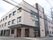 施設は大きな3階建ての建物。外壁には窓が並び、一階にはガラス戸も設置されている。玄関のすぐ脇には車椅子の方専用の駐車スペースがある。
