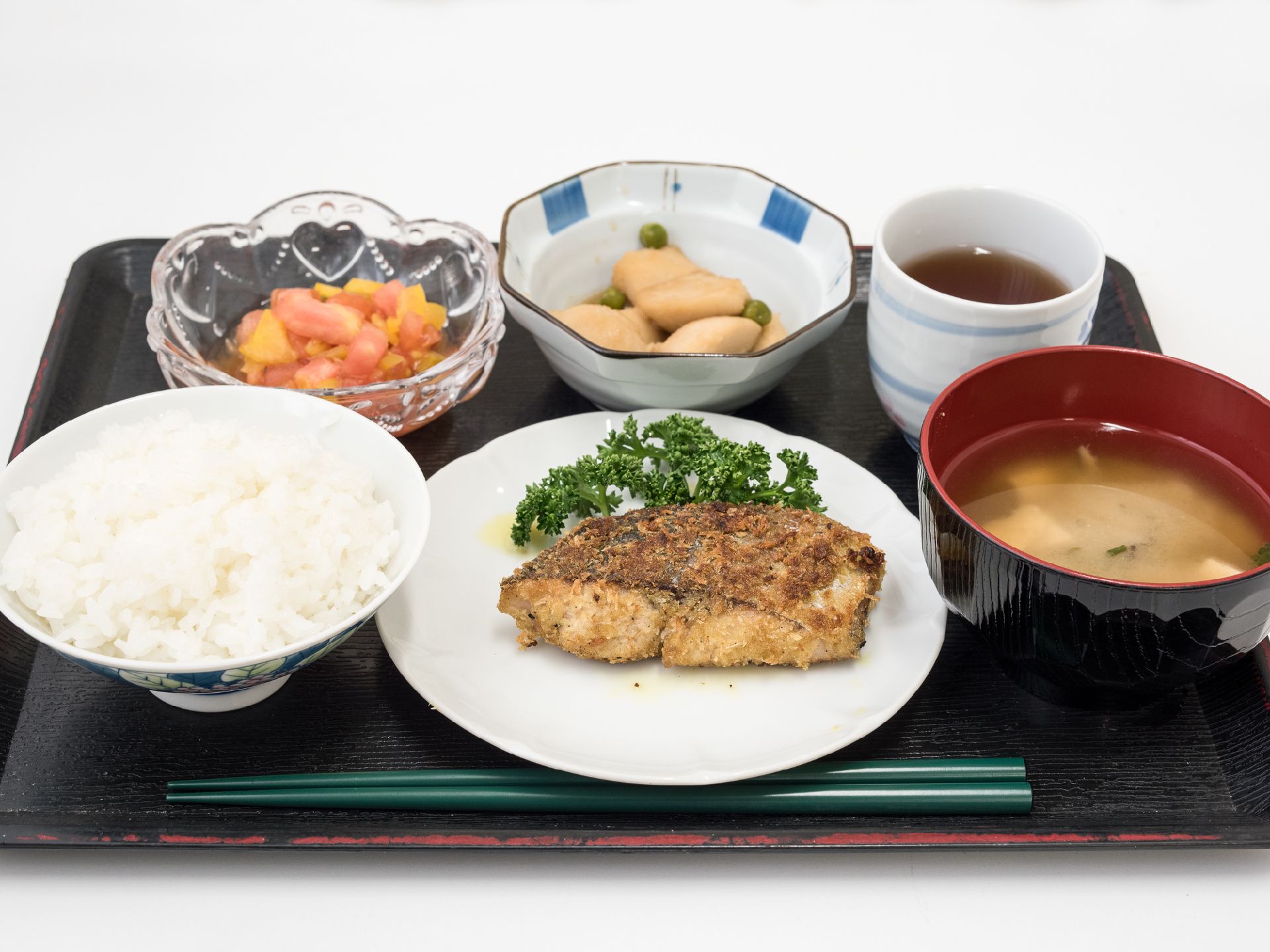 栄養士がバランスを考え、管理された献立。おぼんいっぱいに載せられ、ボリュームもある。食堂で温かい食事の提供をしている。