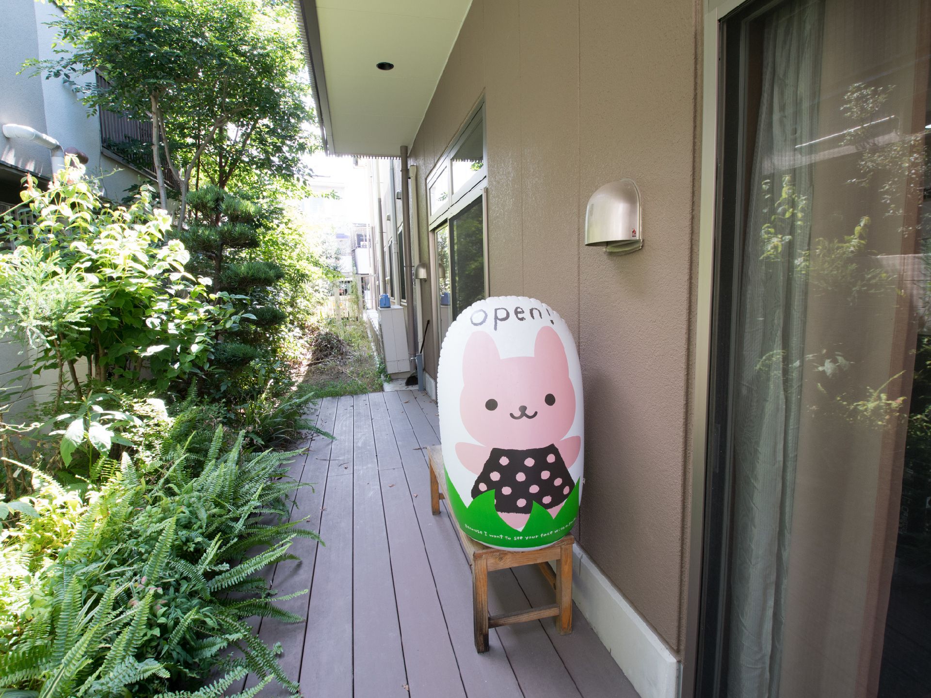 施設の建物の外にはテラスが設けられている。木々がたくさん植えられており、手入れもされている。ウサギの柄の入ったバルーンが置かれている。