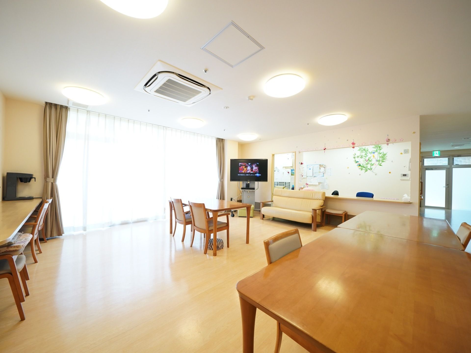 広々とした造りで、開放感ある空間である。部屋の隅に大画面のテレビを完備。テーブルセットのほか、ソファも置かれてある。