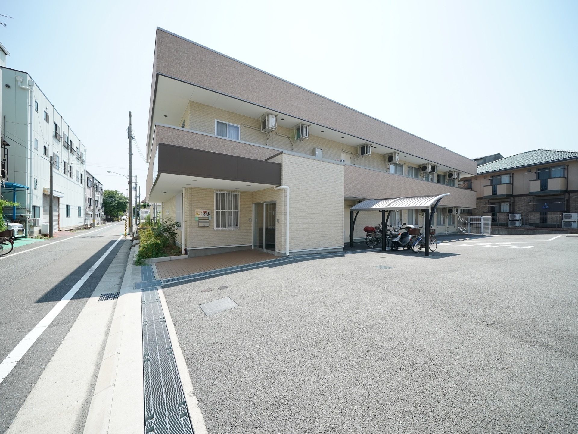 青いチェック柄の車椅子に乗った入居者様に声を掛けるスタッフ