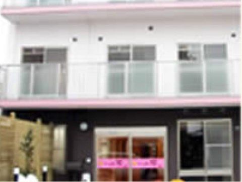 各階のベランダがピンク色に縁取りされている施設外観