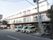 横に長い３階建ての施設である。道路に面して部屋のベランダが並んでいる。窓にはレースのカーテンがかけられている。