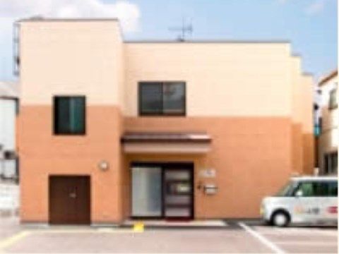 ベージュとオレンジの２色に塗り分けられた２階建ての施設
