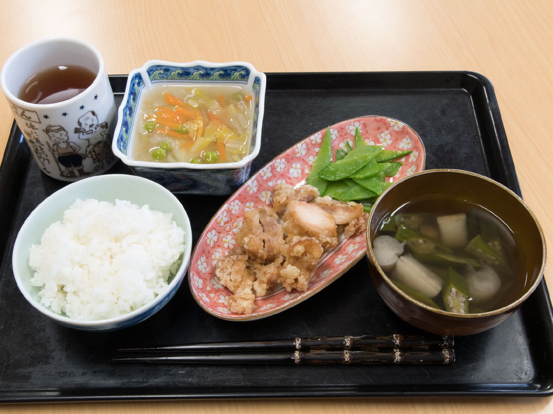 ある日の食事の写真。主菜と添え物、副菜、汁物、ご飯、お茶が1つのお盆に乗せられている。全体的に野菜が多めで栄養バランスが良い。