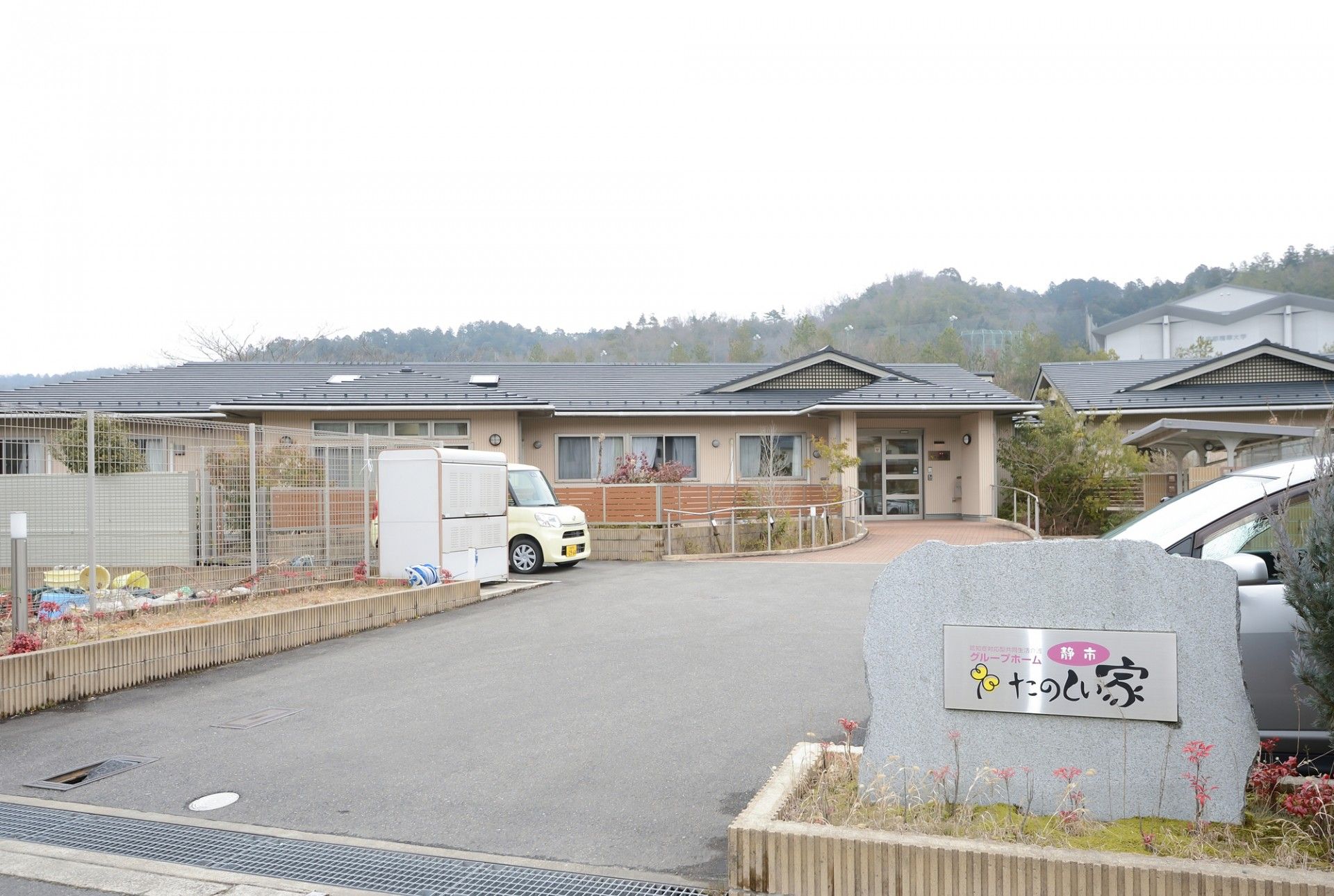 玄関に向かってカーブを描いた道が続いている施設前の広場