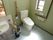 トイレの壁は薄い緑で手すりがココア色とおしゃれな雰囲気。広めに作られているので車いすの方も安心して利用でできる。