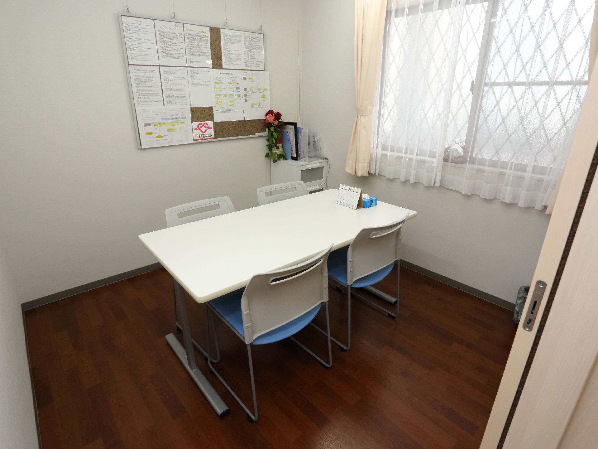 相談室は個室になっていてプライバシーに配慮している。後ろの壁には各種情報をプリントした紙がたくさん掲示されている。
