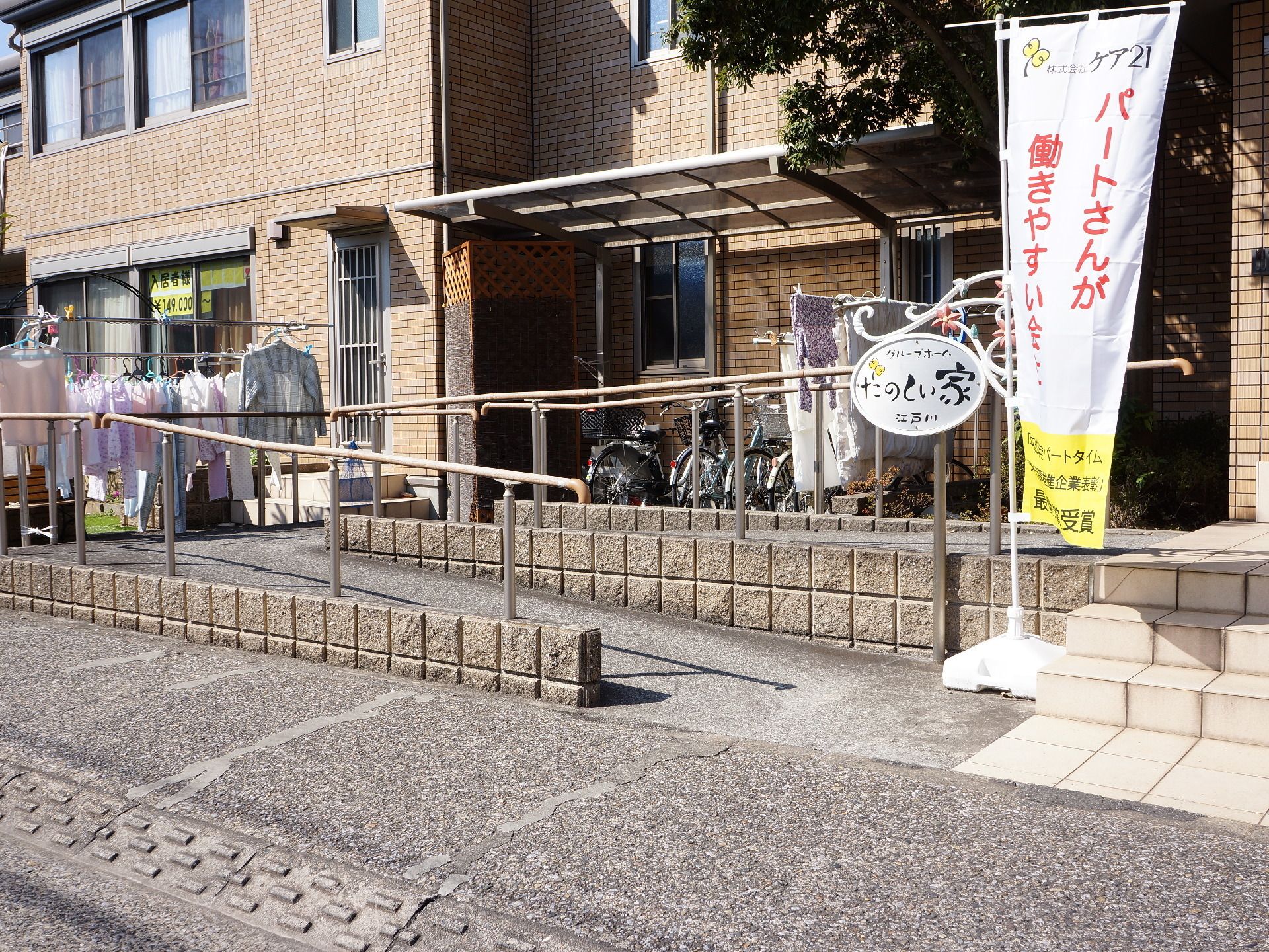白と黄色ののぼりが建物前に立てられている、オレンジ色の施設