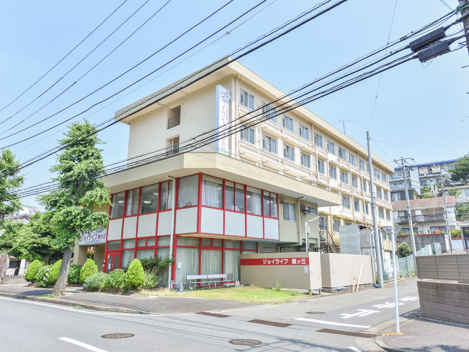 メイン道路に面した建物であるため、車の際はアクセスしやすく分かりやすい。エントランス側には植栽が植えられている。