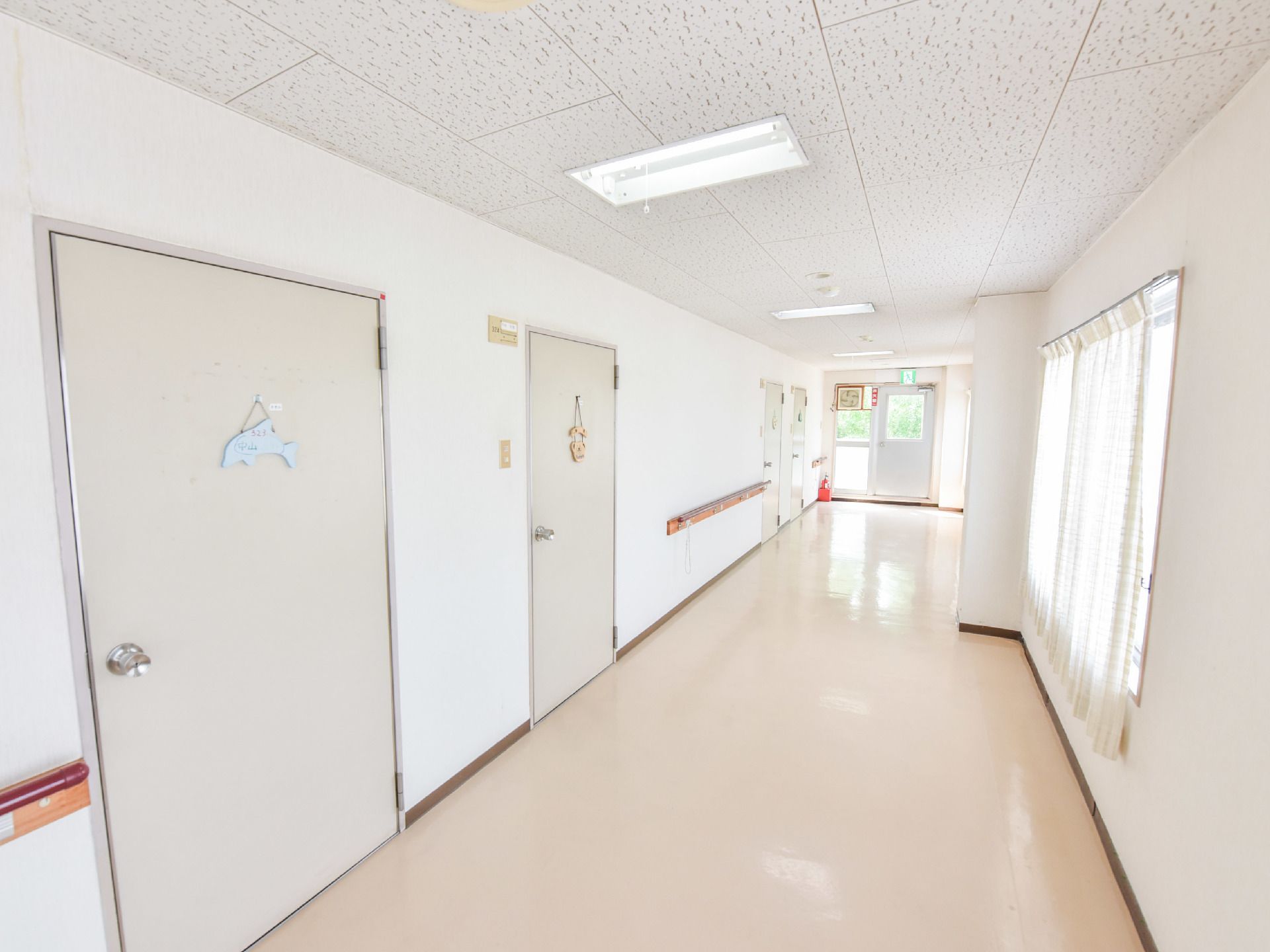 壁に手すりが取り付けられた廊下は、とても明るく幅も広いので車椅子利用者でもストレスなく通行することができる。