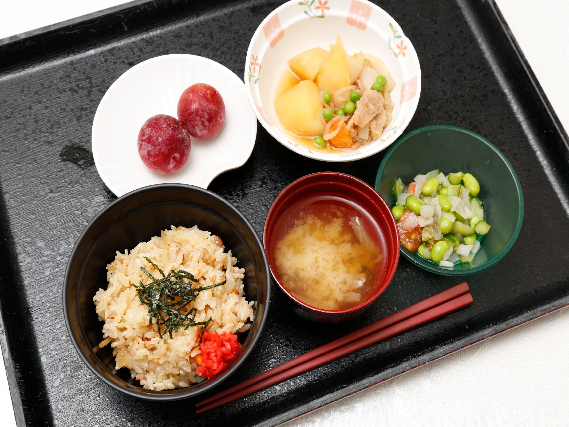 炊き込みのごはん、お味噌汁のほかに、彩りよく様々なおかずが小鉢に盛り付けてある。豆類、肉類、野菜などを使いバランスの良い食事がとれる。