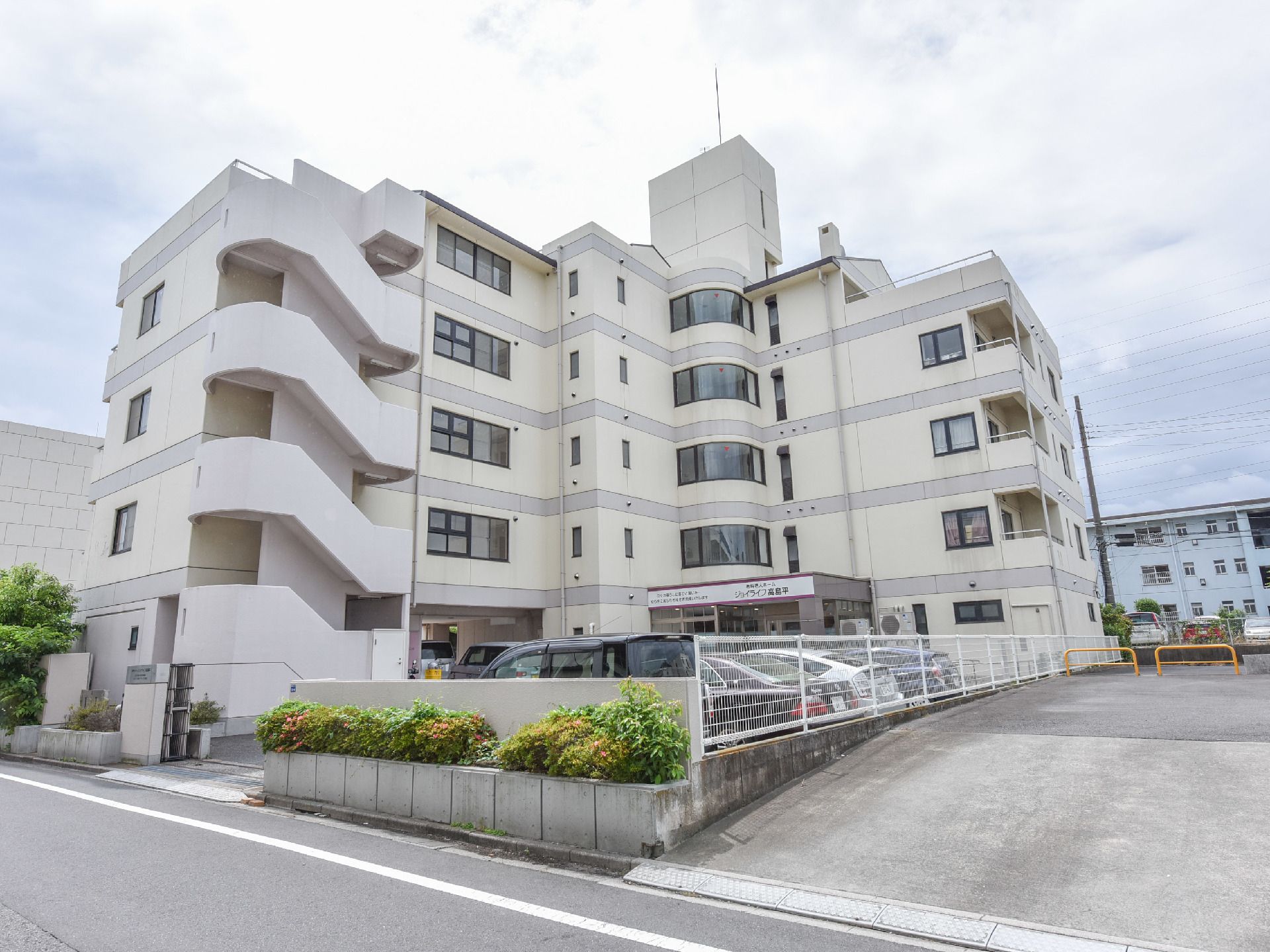 ジョイライフ高島平の外観。きれいなマンションのような施設外観。明るい暖色の外壁となっております。