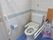 トイレには、手すりが設置されていて使いやすい。温水洗浄便座になっていて、便器の脇にボタンがついているので押しやすくなっている。