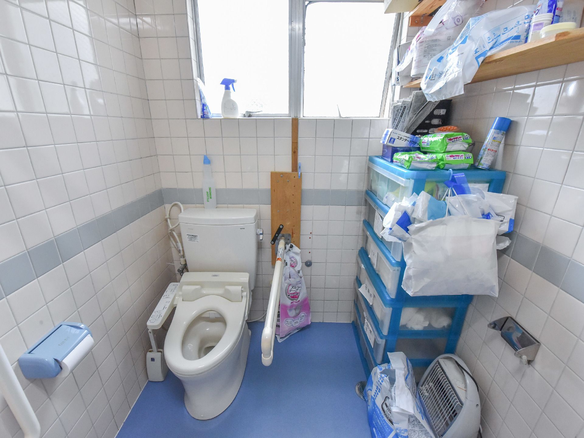 トイレはスペースに余裕があり、消耗品などを置くスペースが作られている。手すりがついていて、窓があるので明るい空間である。