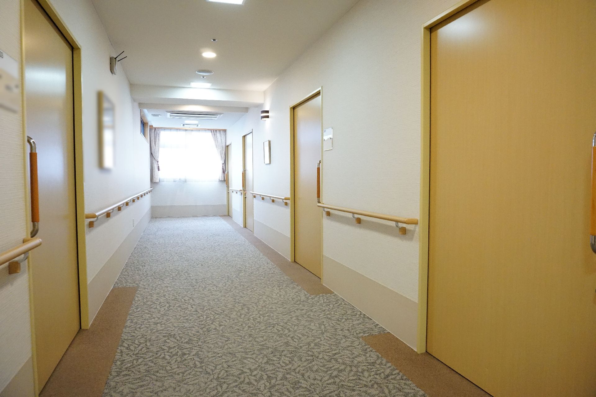 手すりが設置され歩きやすくするためにスペースが広く取られた廊下