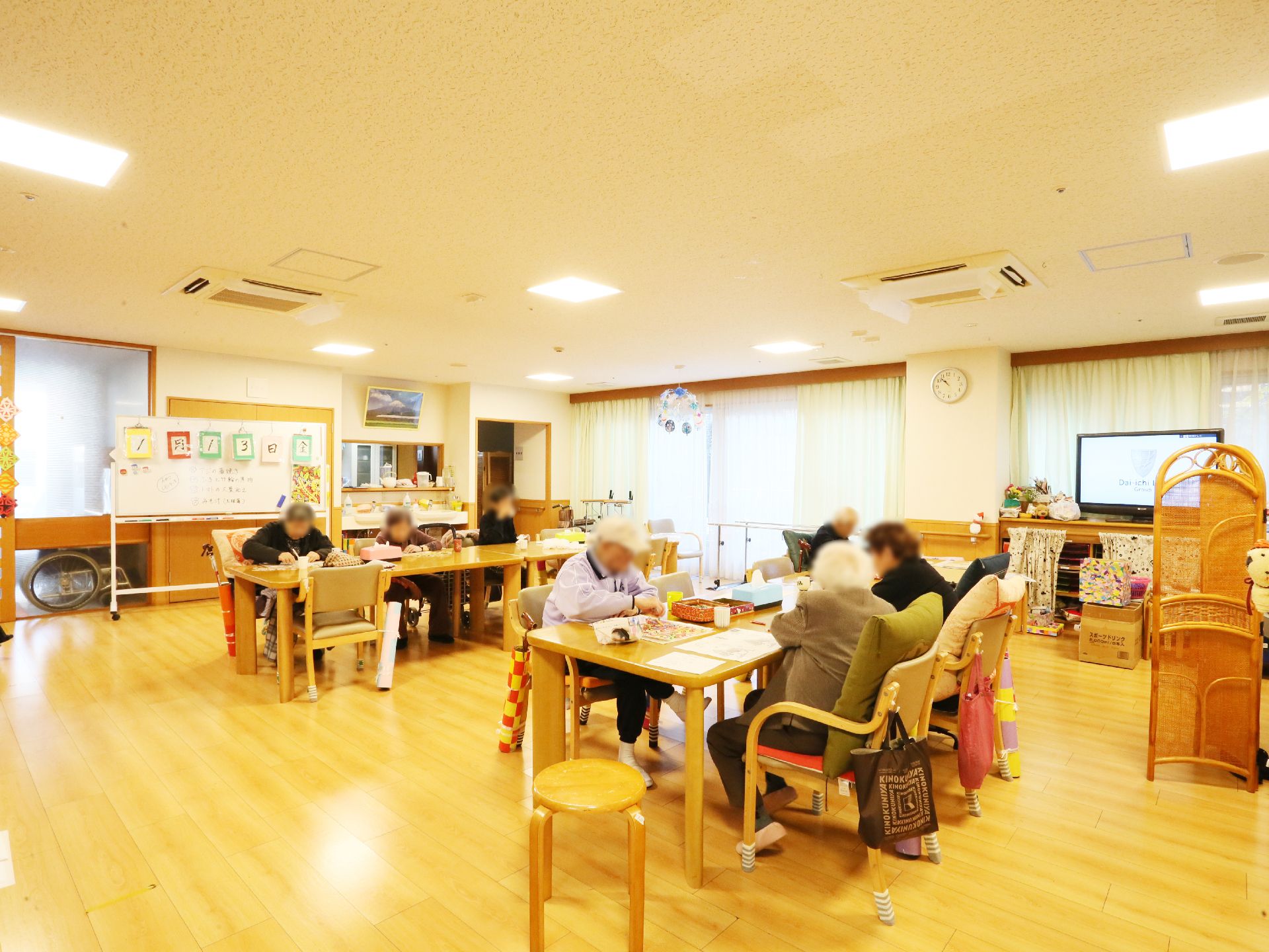 リビングにはテーブルが二列に分けて置かれている。それぞれのテーブルの周りには椅子がそれぞれに置かれている。