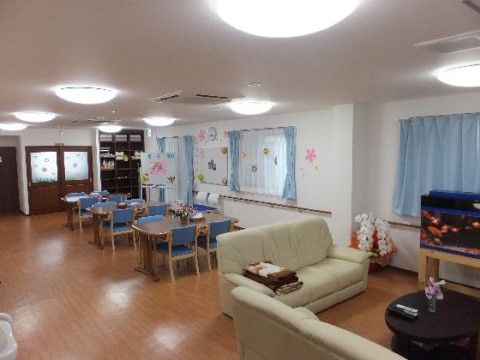 金魚が泳ぐ水槽を囲むようにソファセットが置かれている広間