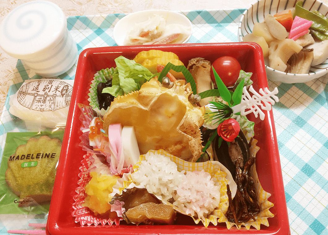 蟹が入った弁当と、煮物と、マドレーヌと最中のセット