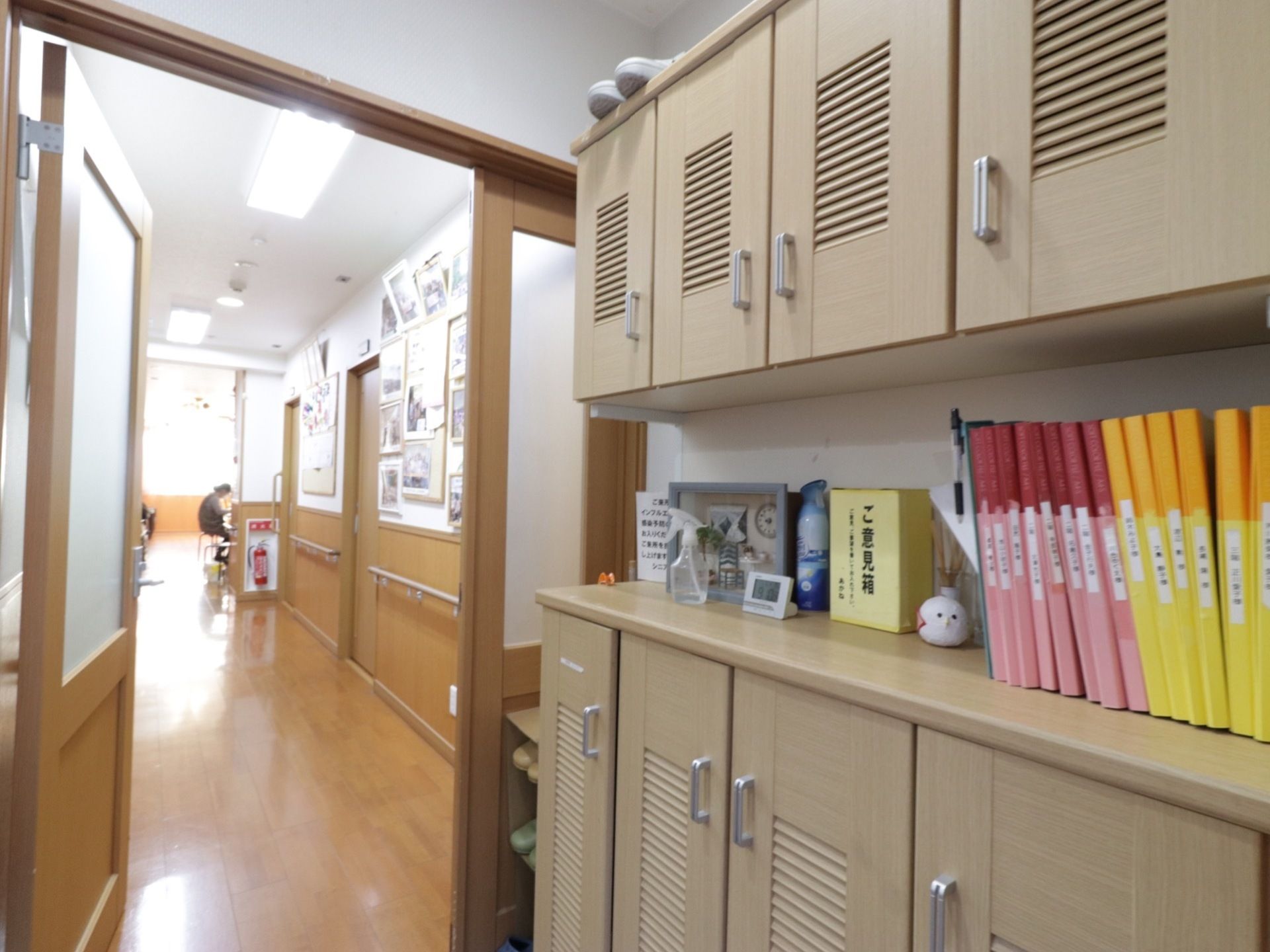 施設内へと続くドアには不透明ガラスをはめ込んでいる。前面には扉付きの下駄箱を設置し、消毒用アルコールを用意している。