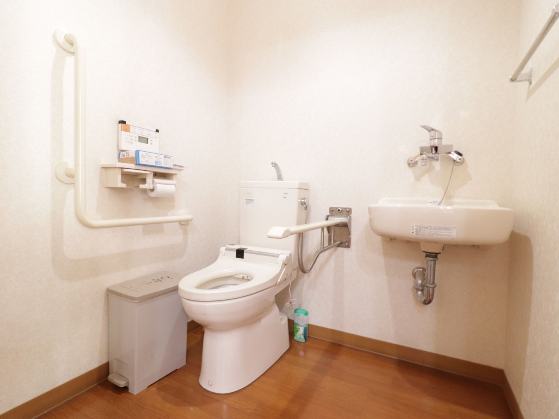 洋式トイレは温水洗浄便座付きで、操作パネルは横の壁に取り付けている。便器の右側に手洗いを設置している。